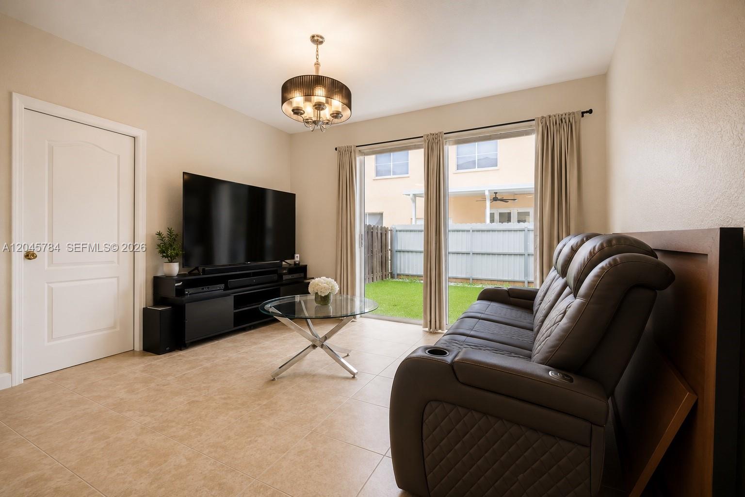 A living room features a dark leather sofa, a glass coffee table, and a television — 3512 SW 171st Ave, Miramar FL 33027, MIRAMAR, FL