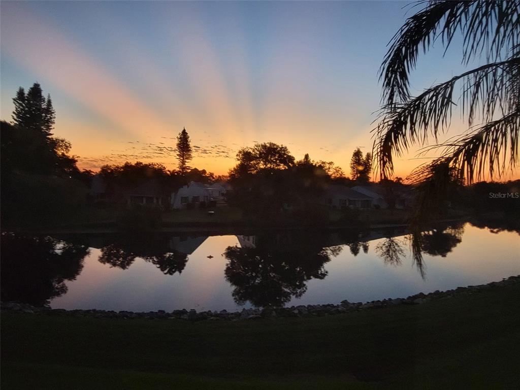 This aerial view shows a residential complex with a pool, tennis courts, and waterfront access — 4859 INDEPENDENCE DRIVE, BRADENTON, FL
