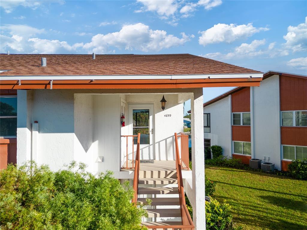 An aerial view of a waterfront condominium complex with multiple buildings, parking, and green spaces — 4859 INDEPENDENCE DRIVE, BRADENTON, FL