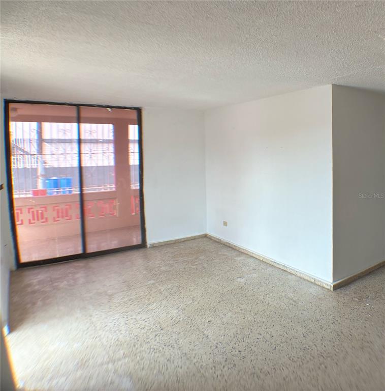 An empty room with terrazzo flooring and sliding glass doors leading to a balcony — 11 LAS VEGAS DEVELOPMENT UNIT N-1, CATANO, PR