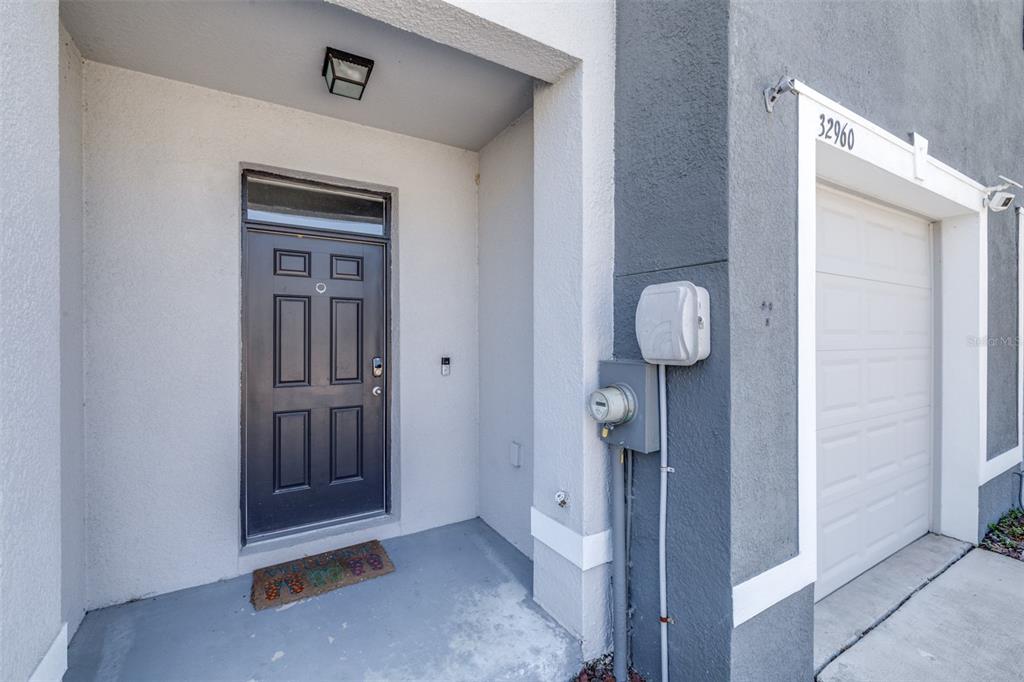 A dark front door and a white garage door are visible on the building's exterior — 32960 KALOKO ROAD, WESLEY CHAPEL, FL