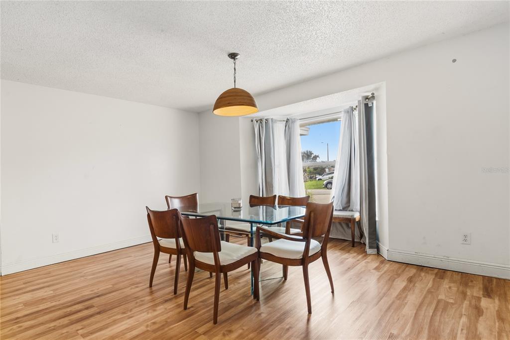 A dining room features a glass table, four wooden chairs, and a bay window — 352 VAIL DRIVE, WINTER HAVEN, FL