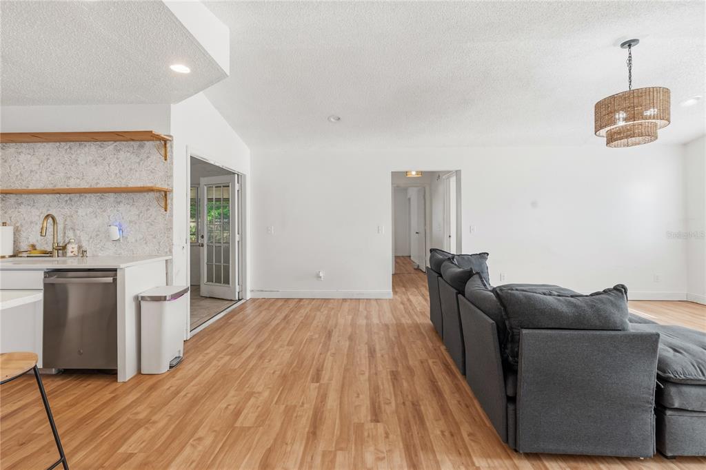 A kitchen area with open shelving and a living room with a gray sectional sofa — 352 VAIL DRIVE, WINTER HAVEN, FL