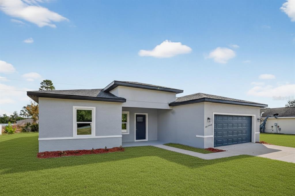 A single-story gray house with a dark blue front door and a two-car garage — 15742 SW 37TH CIRCLE, OCALA, FL