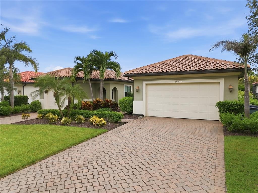 A single-story house with a tiled roof, a two-car garage, and a paved driveway — 10120 BELCREST BOULEVARD, FORT MYERS, FL