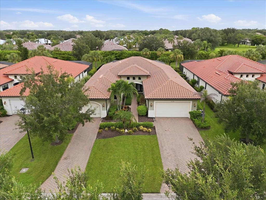 An aerial view shows a single-story house with a tiled roof and two paved driveways — 10120 BELCREST BOULEVARD, FORT MYERS, FL
