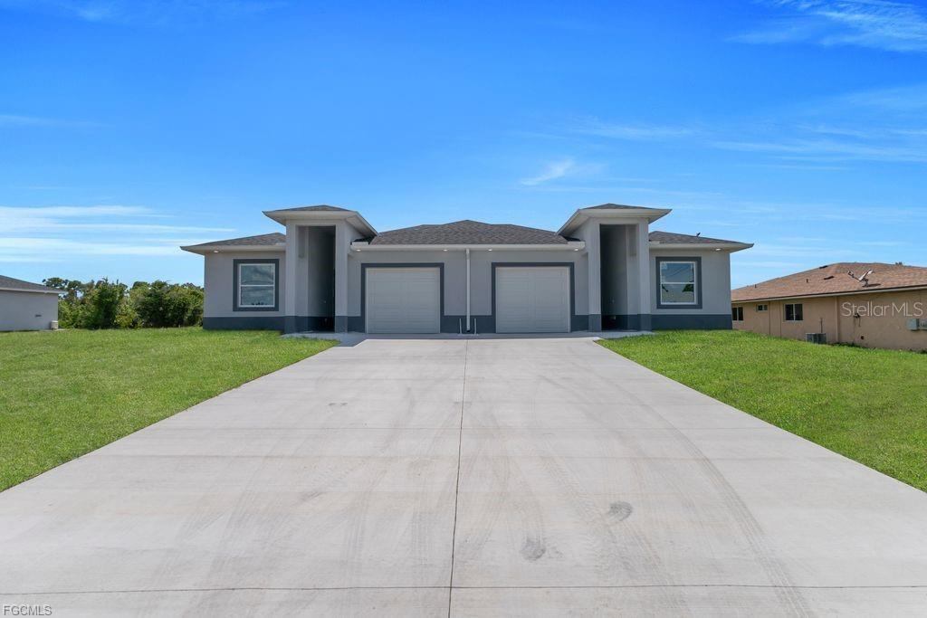 A front exterior view of a single-story duplex with two garages and a concrete driveway — 4648/4650 LEONARD BOULEVARD S, LEHIGH ACRES, FL