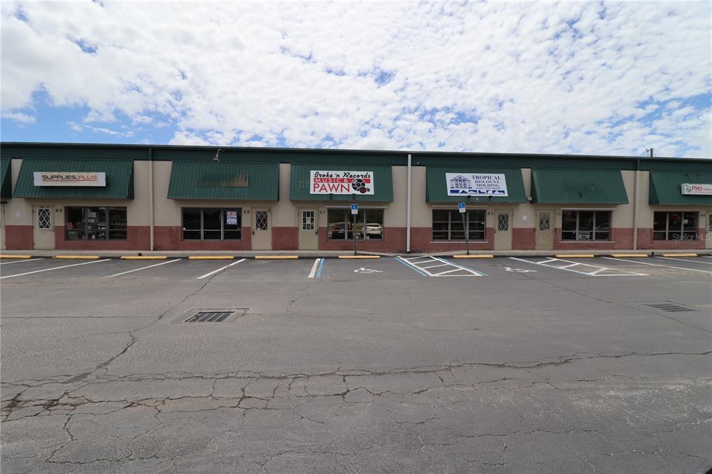A single-story commercial strip mall building with a green metal awning and parking lot — 1225 TAMIAMI TRAIL UNIT A7, PORT CHARLOTTE, FL