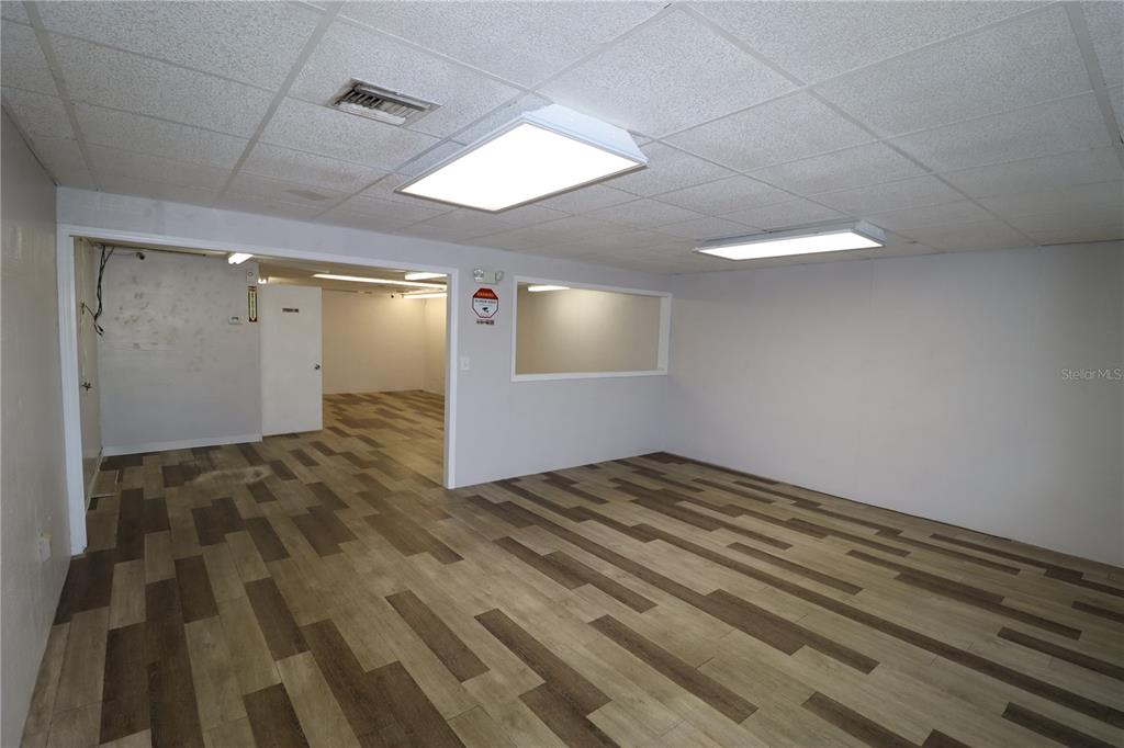 An interior view of a commercial space with wood-look flooring and drop ceiling panels — 1225 TAMIAMI TRAIL UNIT A7, PORT CHARLOTTE, FL