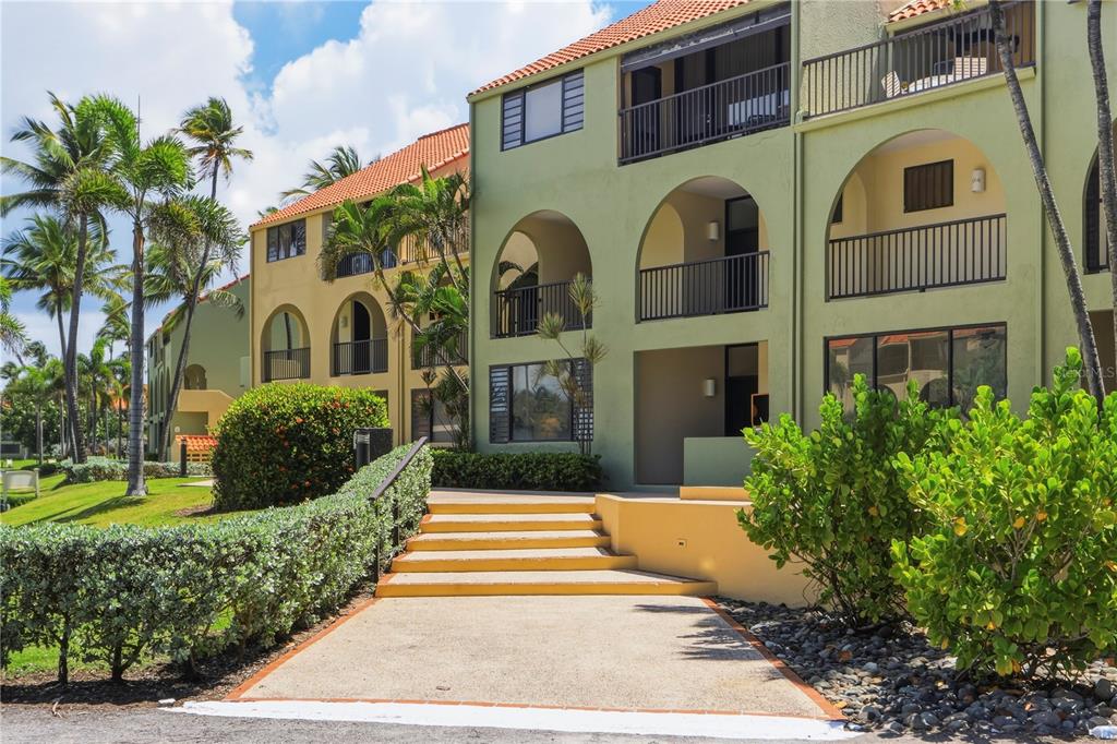 A multi-story apartment building with arched balconies, a concrete walkway, and stairs leading to entrances — 96 BEACH VILLAGE DRIVE UNIT 96, HUMACAO, PR