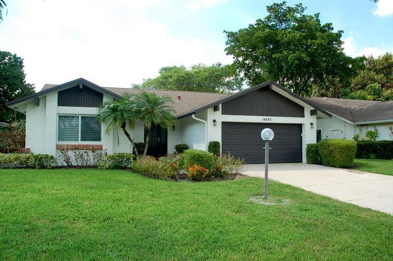 A single-story house with a white stucco exterior, dark brown accents, and a two-car garage — 16843 Boca Delray Drive, Delray Beach FL 33484, DELRAY BEACH, FL