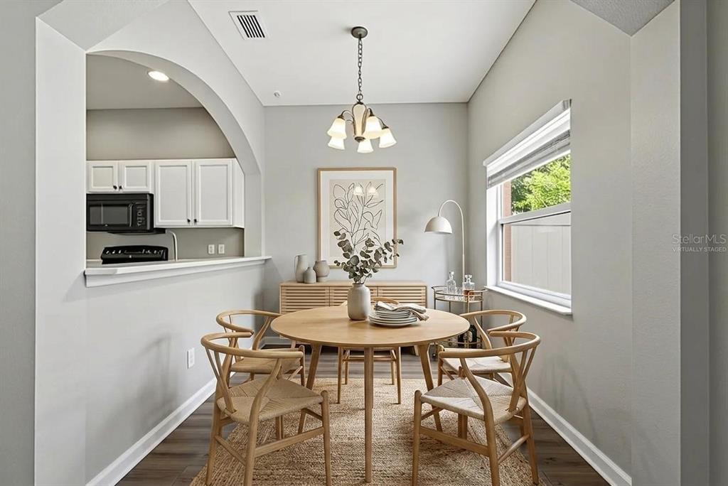 A dining area features a round wooden table, four chairs, and a kitchen pass-through window — 901 PINE POINTE LANE, ORLANDO, FL