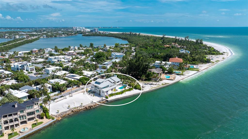 An aerial view shows a multi-story waterfront house with a pool on a sandy beach — 1209 WESTWAY DRIVE, SARASOTA, FL