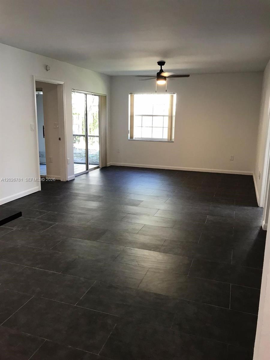 A kitchen features white cabinets, black countertops, stainless steel appliances, and dark tile flooring — 462 NE 210th Cir Ter # 9, Miami FL 33179, MIAMI, FL
