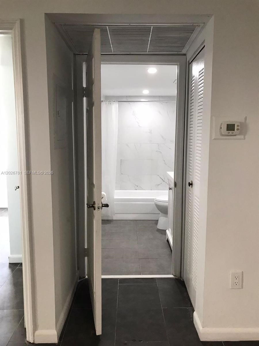 A kitchen features white cabinets, stainless steel appliances, and dark countertops over tiled flooring — 462 NE 210th Cir Ter # 9, Miami FL 33179, MIAMI, FL