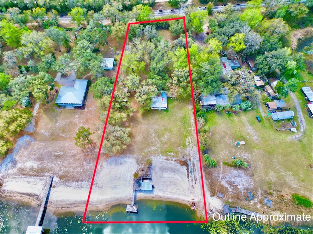 An aerial view shows a waterfront property outlined in red with a house and dock — 106 E SUNNYSIDE BEACH ROAD, HAWTHORNE, FL