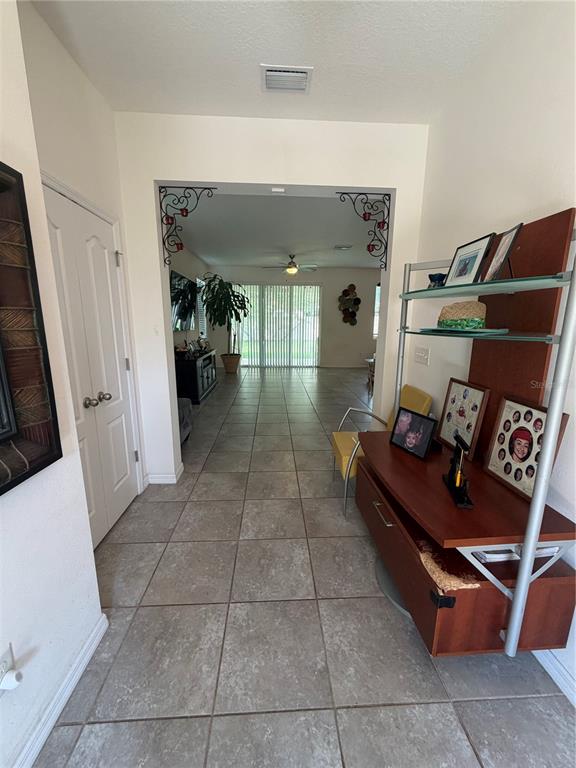 A tiled entryway leads through a decorative arched opening into a living area with sliding doors — 6305 SUNSAIL PLACE, APOLLO BEACH, FL