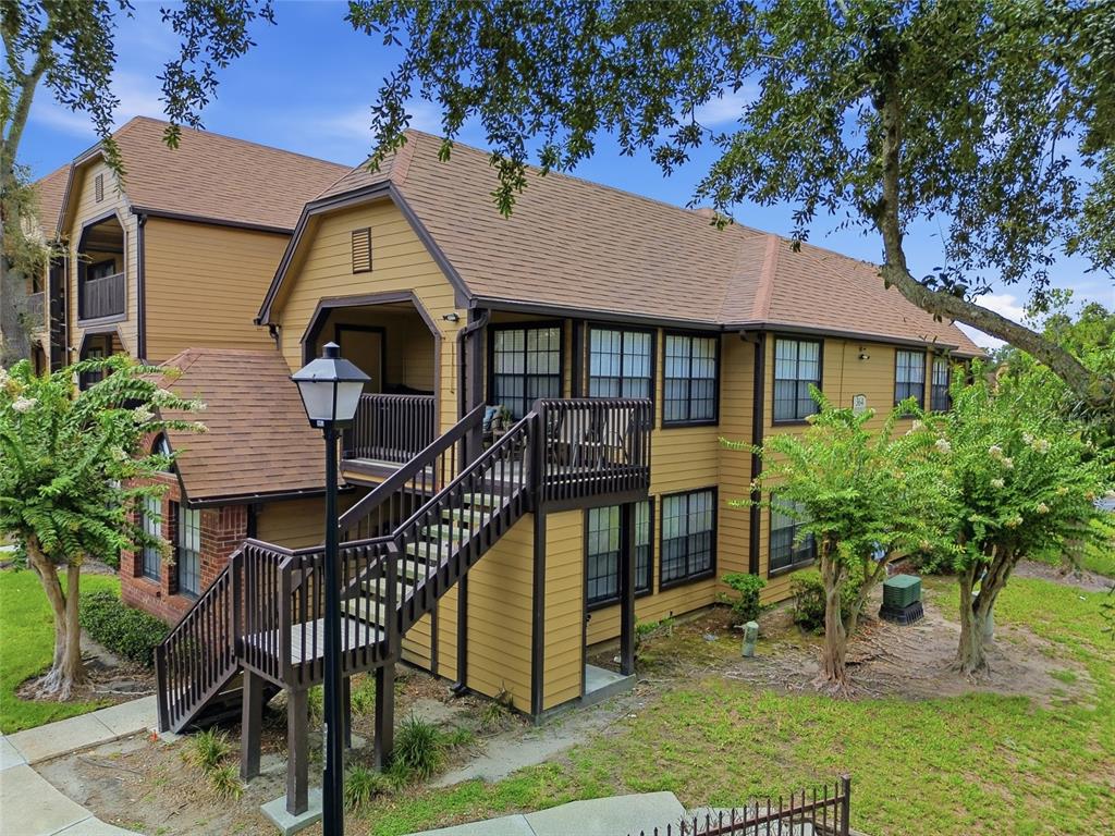 A two-story apartment building with tan siding, brown trim, and an exterior wooden staircase — 364 NORTHPOINTE COURT UNIT 208, ALTAMONTE SPRINGS, FL