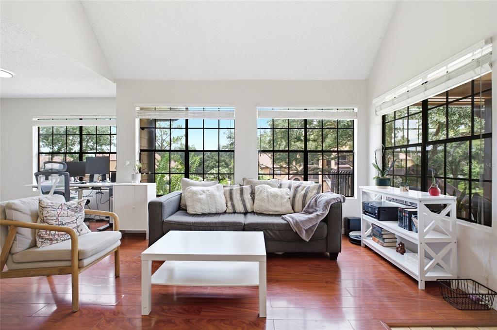 A living room features hardwood floors, a gray sofa, a white coffee table, and large windows — 364 NORTHPOINTE COURT UNIT 208, ALTAMONTE SPRINGS, FL
