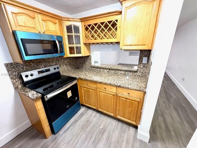 A kitchen features light wood cabinets, granite countertops, and a stainless steel stove — 1945 NW 29th St # A8, Miami FL 33142, MIAMI, FL