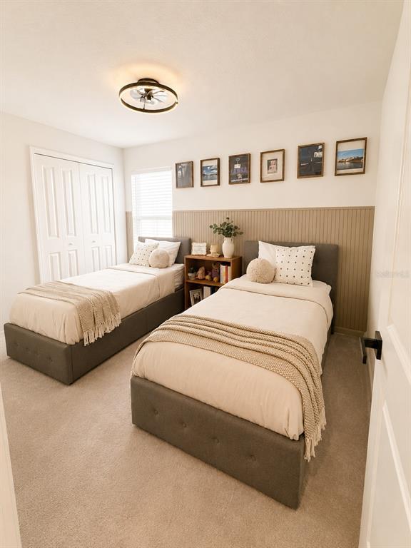A bedroom features two twin beds, a central nightstand, and a paneled accent wall — 1322 INKBERRY CIRCLE, DELAND, FL