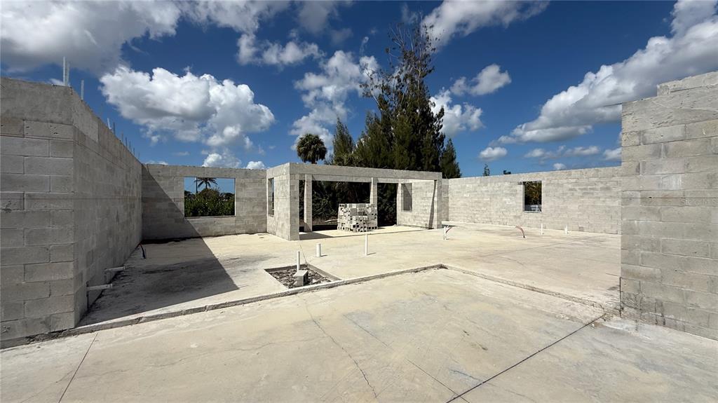 An unfinished concrete block structure stands on a concrete slab under a blue sky — 2310 NW 35TH PLACE, CAPE CORAL, FL
