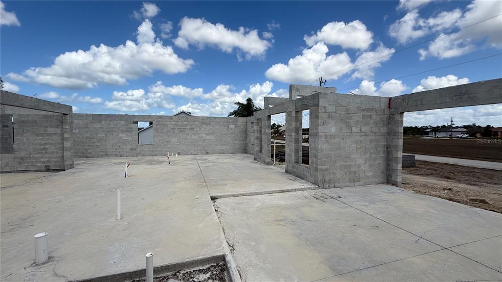 The exterior of a house under construction shows concrete block walls and a concrete slab — 2310 NW 35TH PLACE, CAPE CORAL, FL
