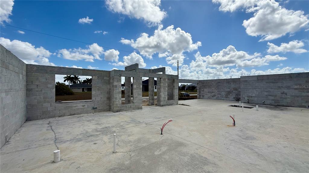 An unfinished concrete block structure stands on a concrete slab under a blue sky — 2310 NW 35TH PLACE, CAPE CORAL, FL