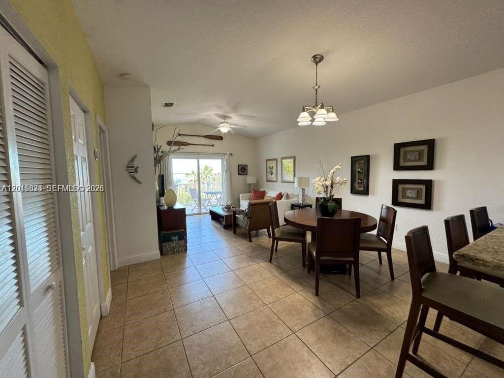 An open-concept living and dining area features tile flooring, a ceiling fan, and sliding doors — 65A Bimini Bay Resort # 302, FL, FL