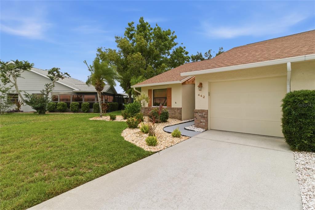 A single-story house with a beige exterior, a one-car garage, and a landscaped front yard — 442 PENDLETON DRIVE, VENICE, FL