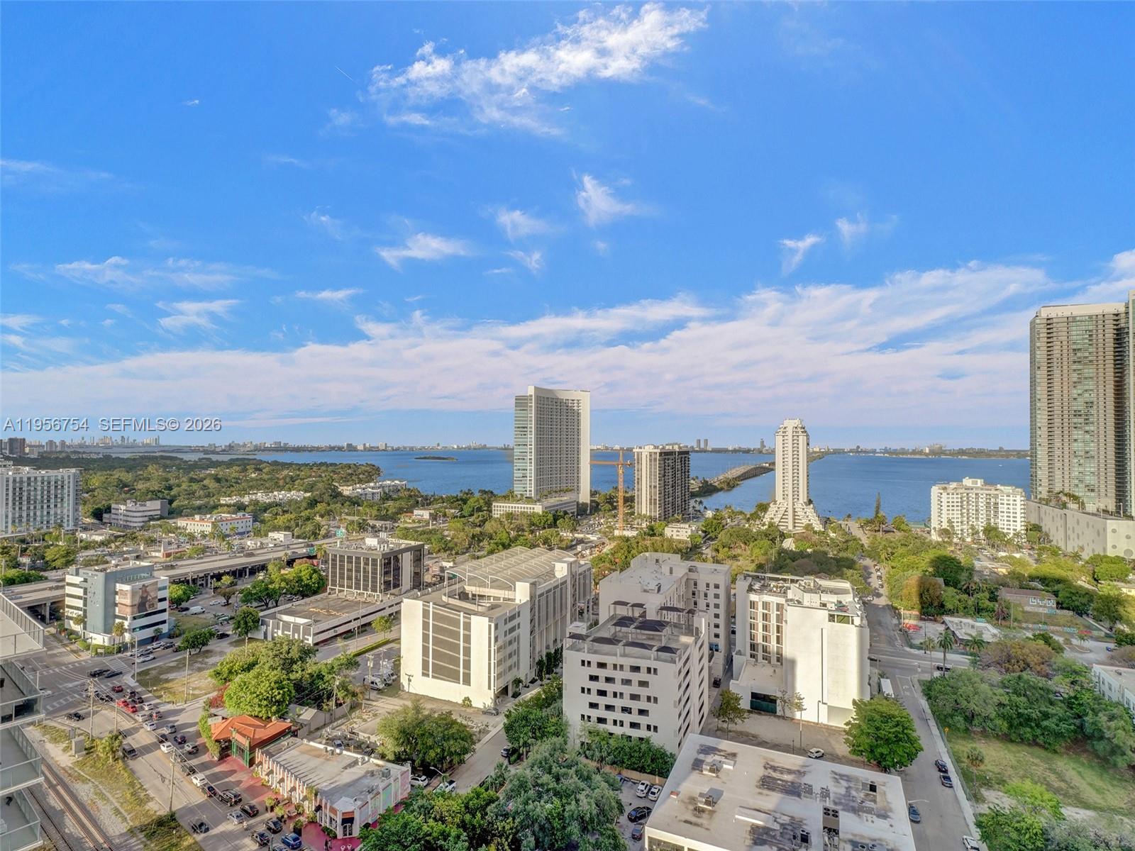 An elevated view shows a city skyline with multiple high-rise buildings overlooking a large bay — 121 NE 34th St # 2106A, Miami FL 33137, MIAMI, FL