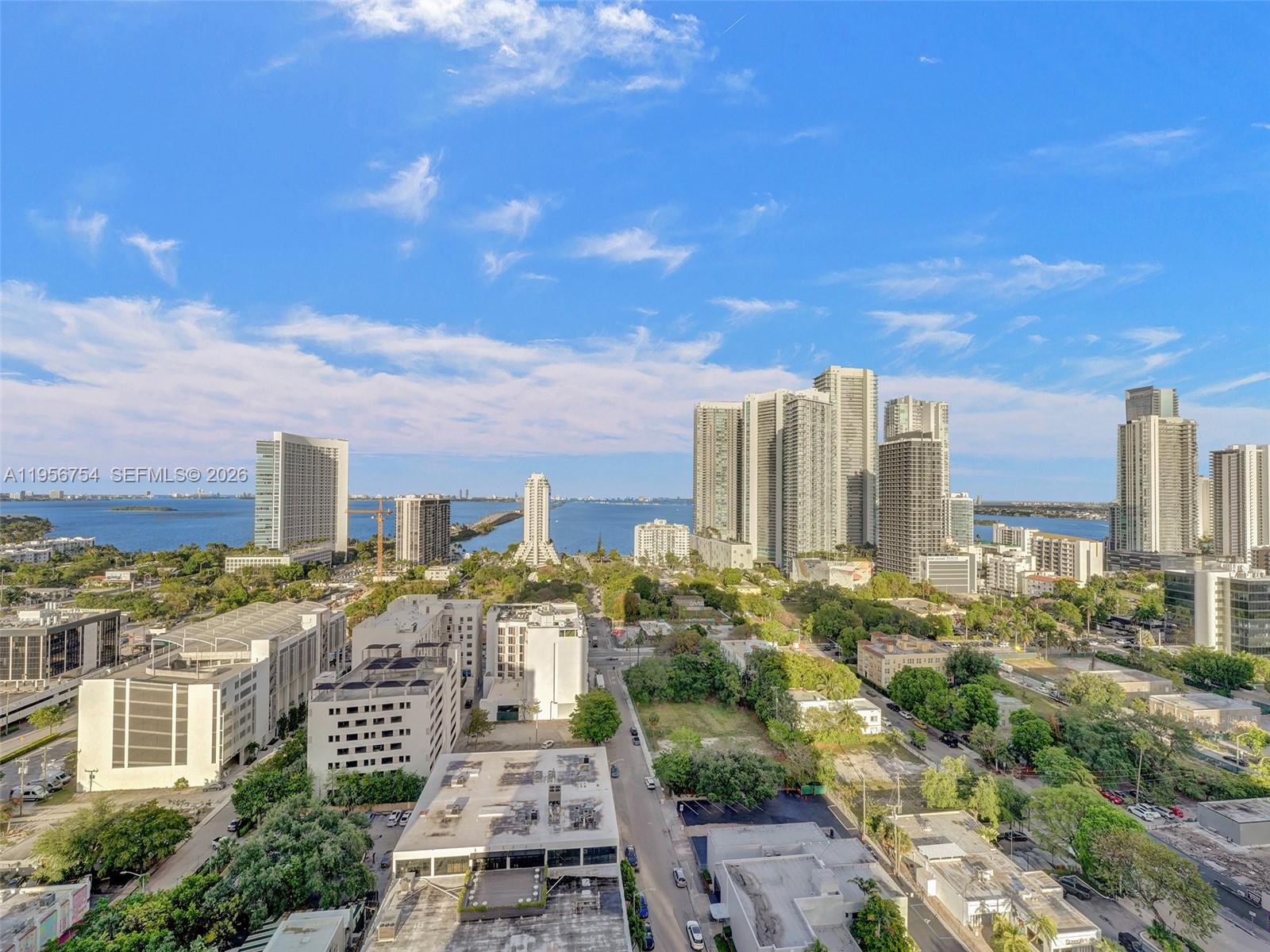 An elevated view of a city skyline featuring high-rise buildings, green spaces, and a bay — 121 NE 34th St # 2106A, Miami FL 33137, MIAMI, FL