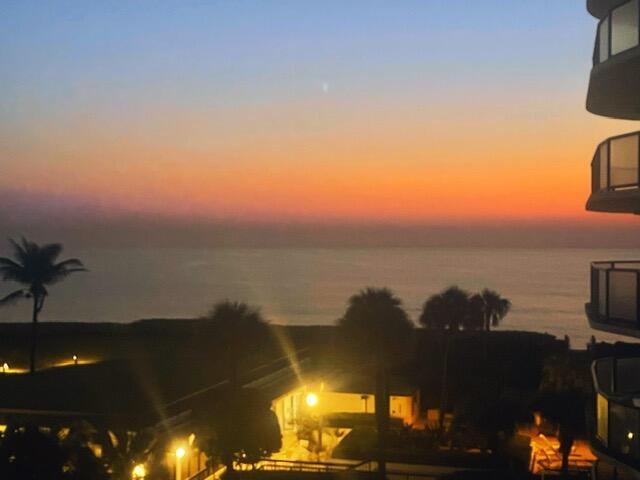 A balcony view overlooks a beach and ocean during a colorful sunset — 3440 S Ocean Boulevard # 204s, Palm Beach FL 33480, PALM BEACH, FL