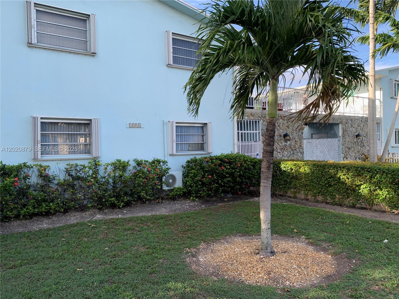 A light blue two-story building features louvered windows, a palm tree, and a stone facade — 1581 NE 8th St # 7, Homestead FL 33033, HOMESTEAD, FL