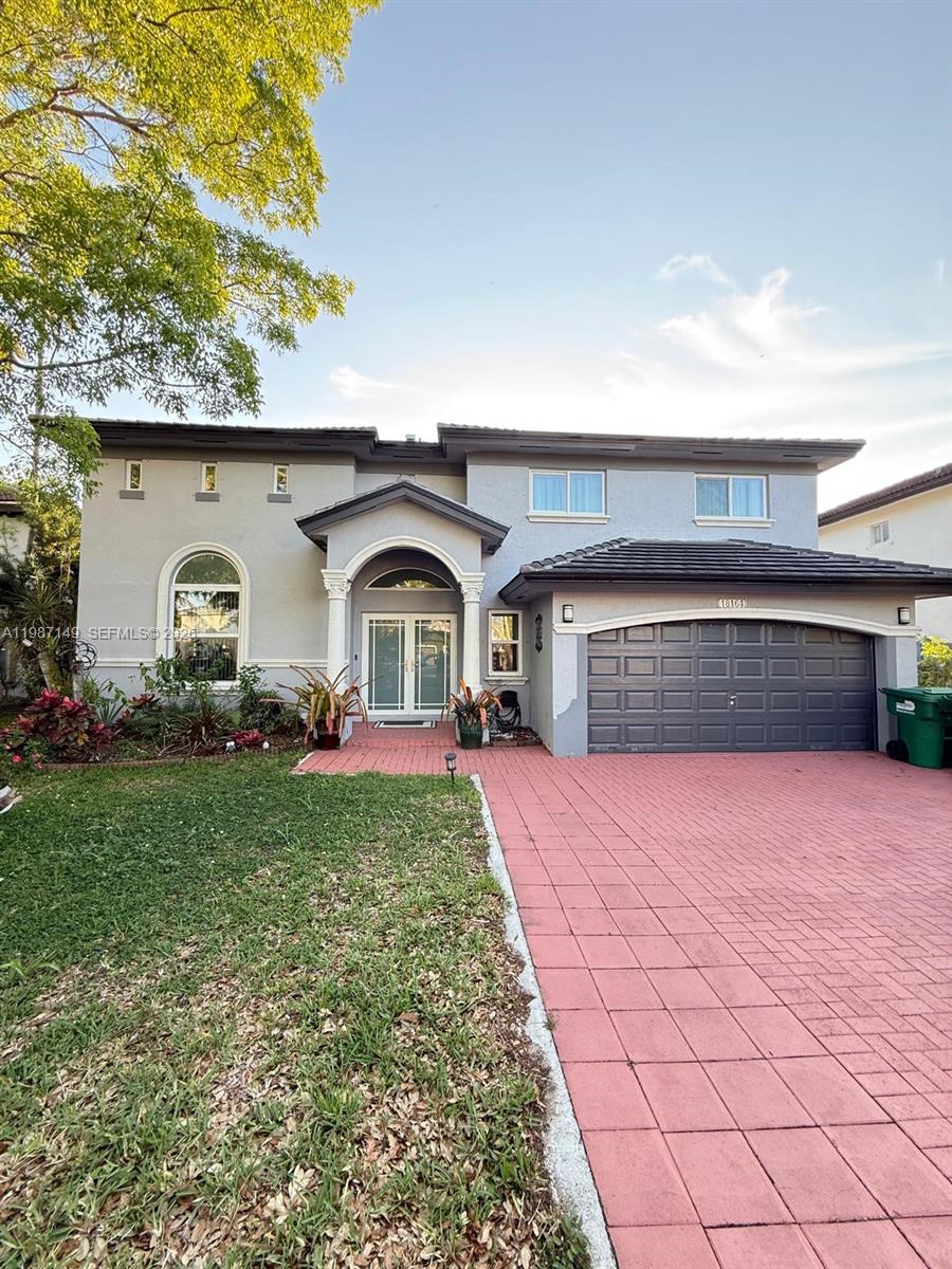 A two-story house with a gray stucco exterior, a tiled roof, and a red driveway — 18164 SW 149th Pl, Miami FL 33187, MIAMI, FL