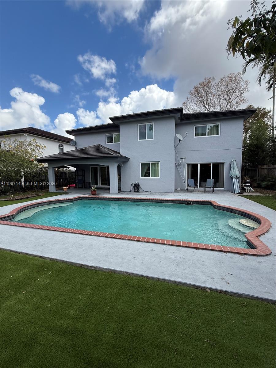 A two-story house with a gray exterior features a backyard swimming pool and patio — 18164 SW 149th Pl, Miami FL 33187, MIAMI, FL