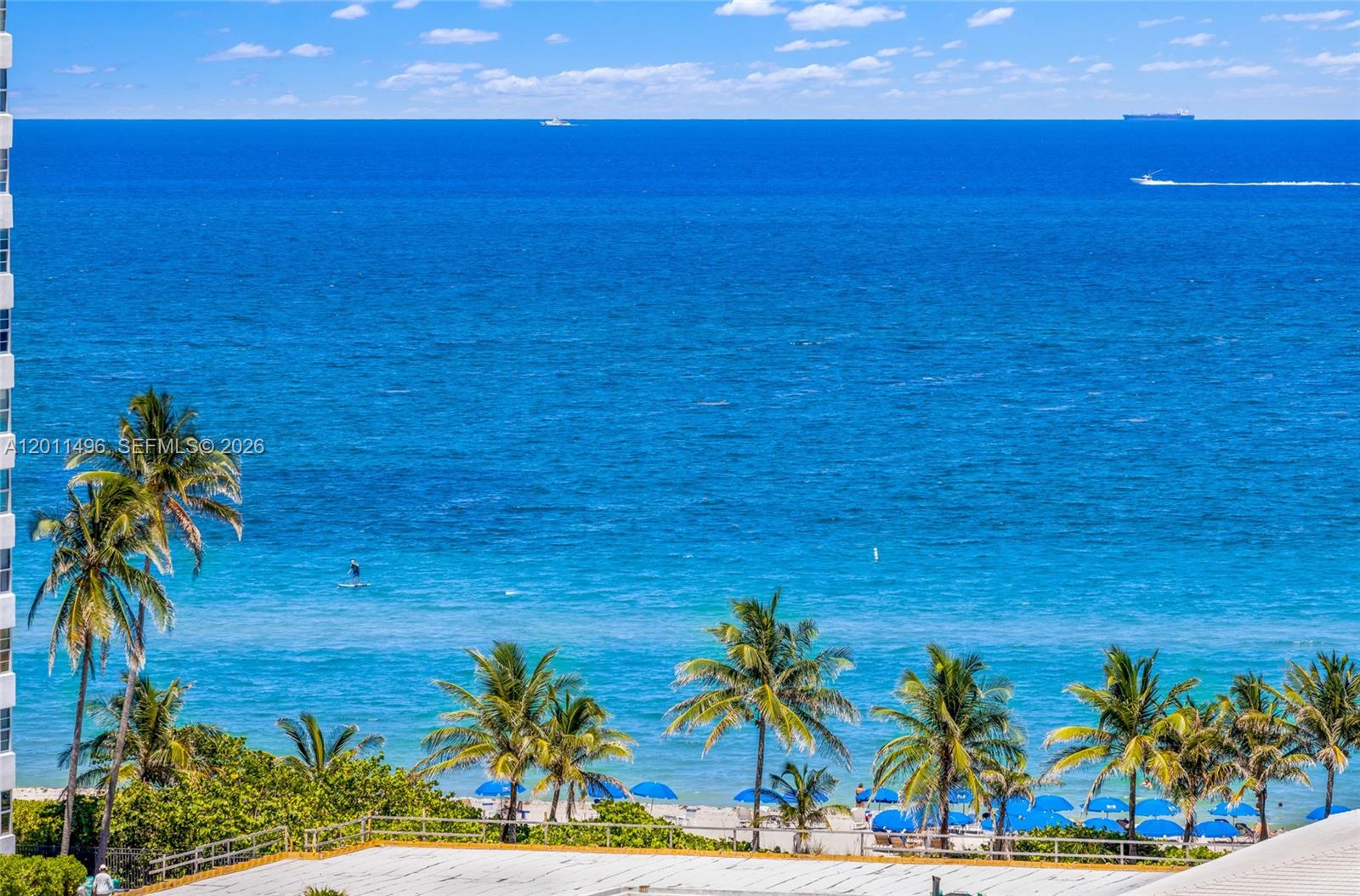 A high-angle view shows a sandy beach with palm trees overlooking the blue ocean — 1985 S Ocean Dr # 10B, Hallandale Beach FL 33009, HALLANDALE BEACH, FL