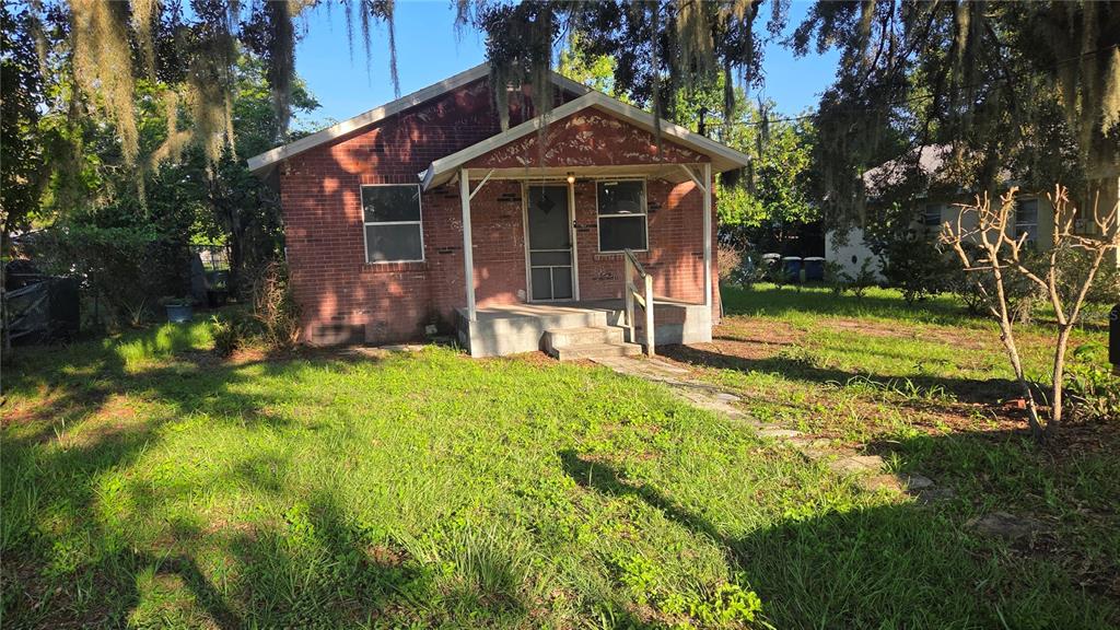 A single-story red brick house with a front porch and a stone walkway — 1135 FAIRVIEW AVENUE, BARTOW, FL