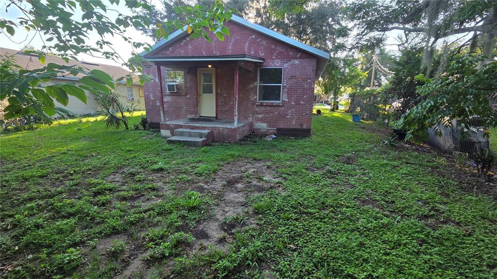 A small, single-story red brick house with a front porch and a grassy yard — 1135 FAIRVIEW AVENUE, BARTOW, FL