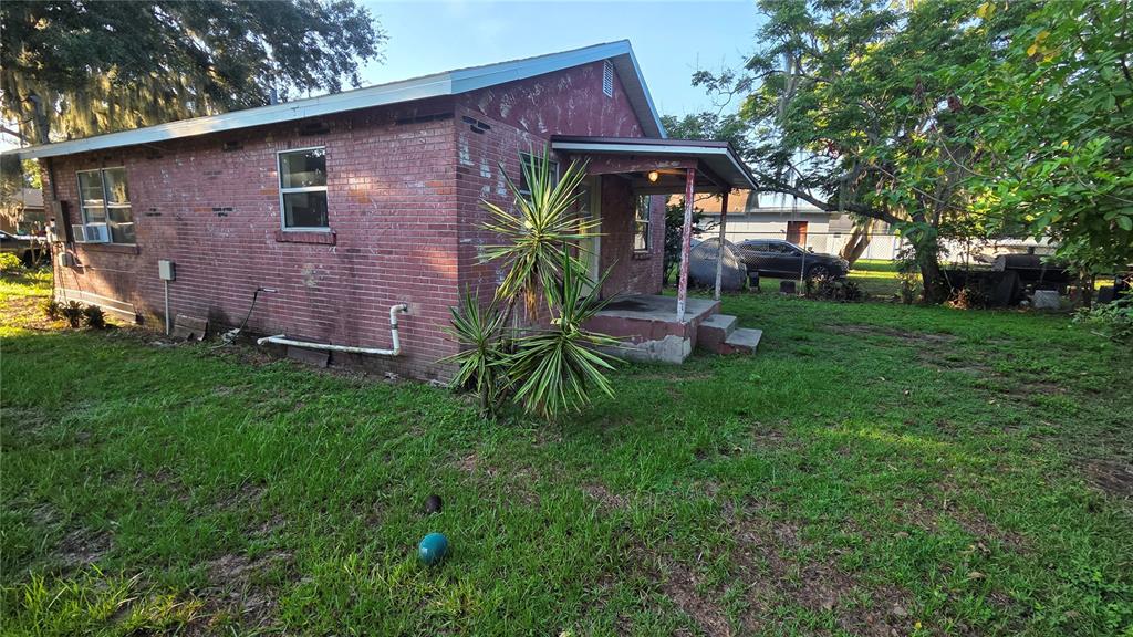 A red brick house with a small covered porch and a grassy yard — 1135 FAIRVIEW AVENUE, BARTOW, FL