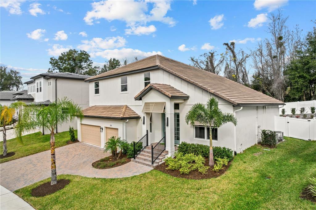 A two-story suburban house with a tan tile roof, beige stucco siding, and paved driveway — 531 SANCTUARY GOLF PLACE, APOPKA, FL