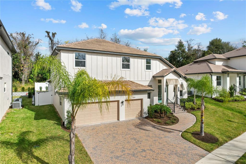 A two-story house with a tan tile roof, white siding, and a brick paver driveway — 531 SANCTUARY GOLF PLACE, APOPKA, FL