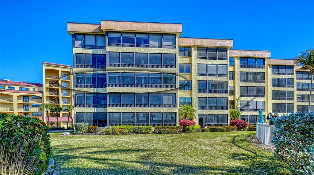An aerial view of a beachfront resort with multiple buildings, a pool, and turquoise water — 8764 MIDNIGHT PASS ROAD UNIT A306, SARASOTA, FL
