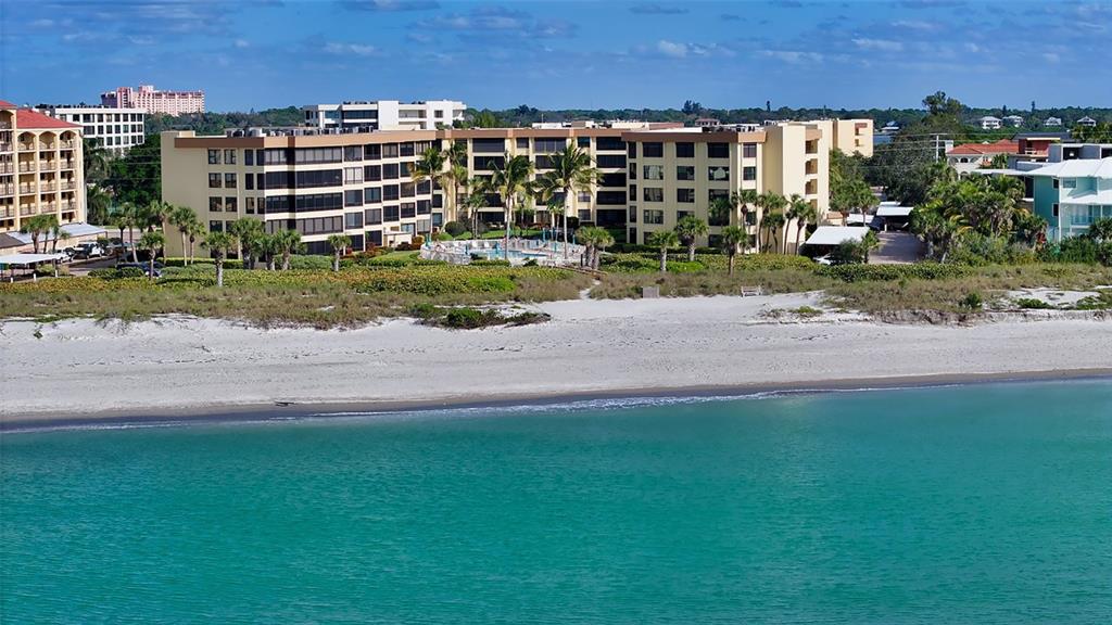 An outdoor balcony with stone-patterned flooring, a metal railing, and an exit door — 8764 MIDNIGHT PASS ROAD UNIT A306, SARASOTA, FL