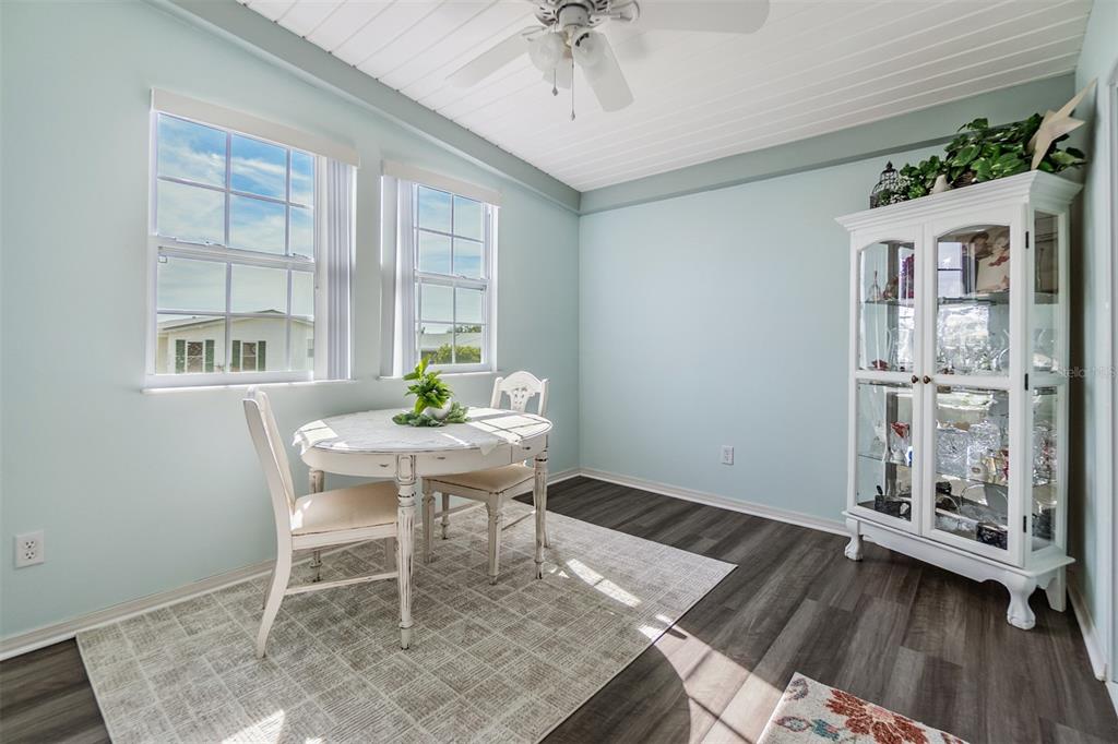A dining room with light blue walls, a white china cabinet, and a small table — 37443 GILL AVENUE, ZEPHYRHILLS, FL