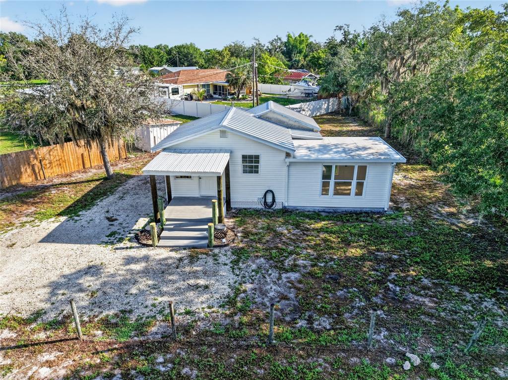 An aerial view of a white, single-story house with a metal roof and front porch — 8024 HILLMAN AVENUE, PUNTA GORDA, FL