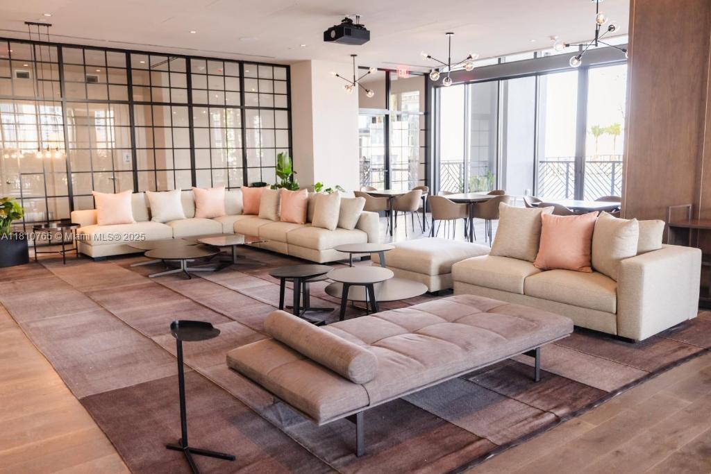 A modern lounge area features a large sectional sofa, a daybed, and floor-to-ceiling windows — 159 NE 6TH ST # 3205, Miami FL 33132, MIAMI, FL