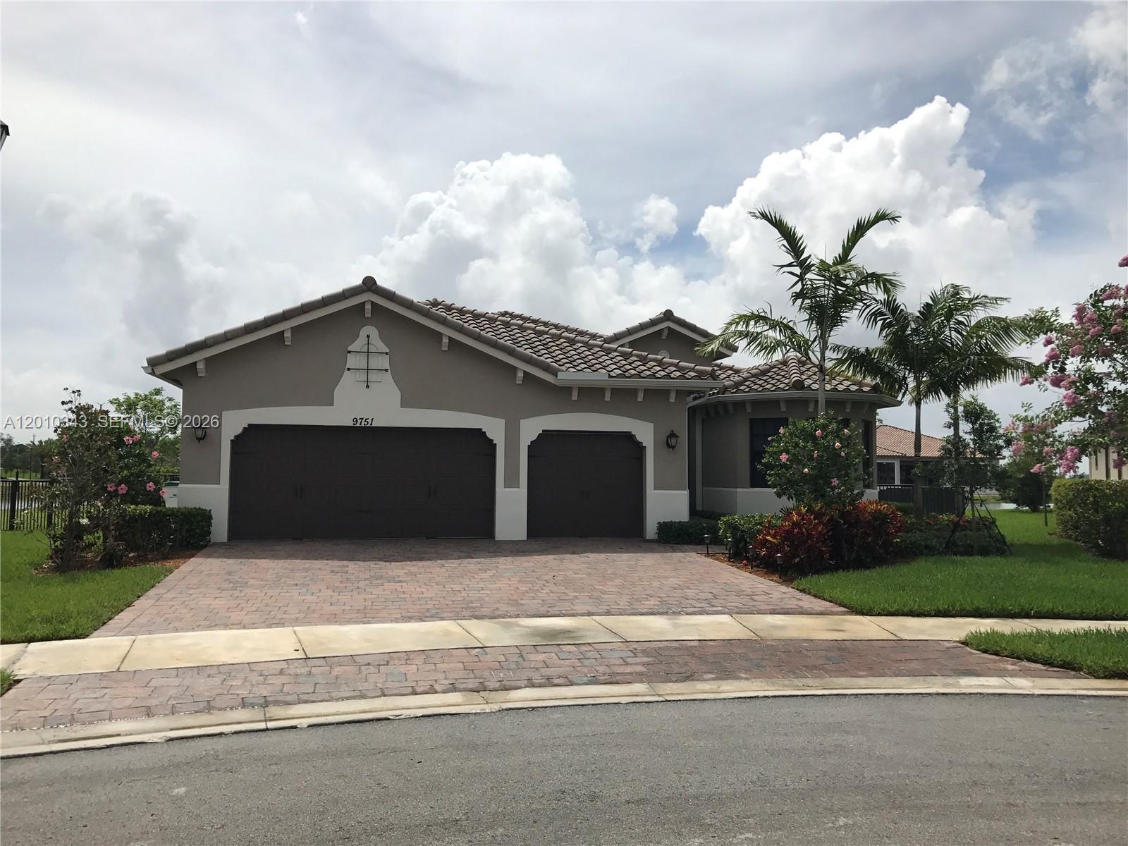 A single-story house with a three-car garage, tile roof, and a paved driveway — 9751 Lakeview Ln, Parkland FL 33076, PARKLAND, FL