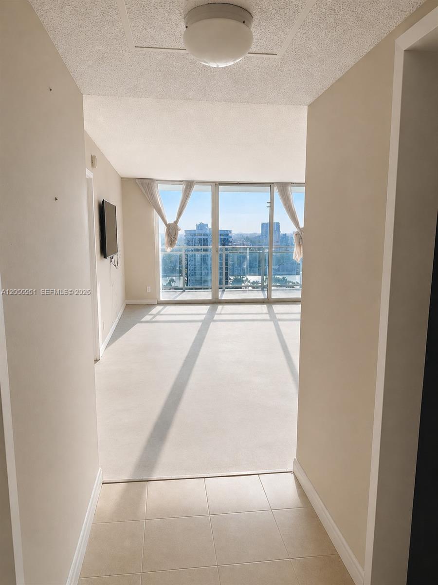 A tiled entryway leads into a bright living area with floor-to-ceiling windows and balcony access — 2030 S Ocean Dr # 1503, Hallandale Beach FL 33009, HALLANDALE BEACH, FL