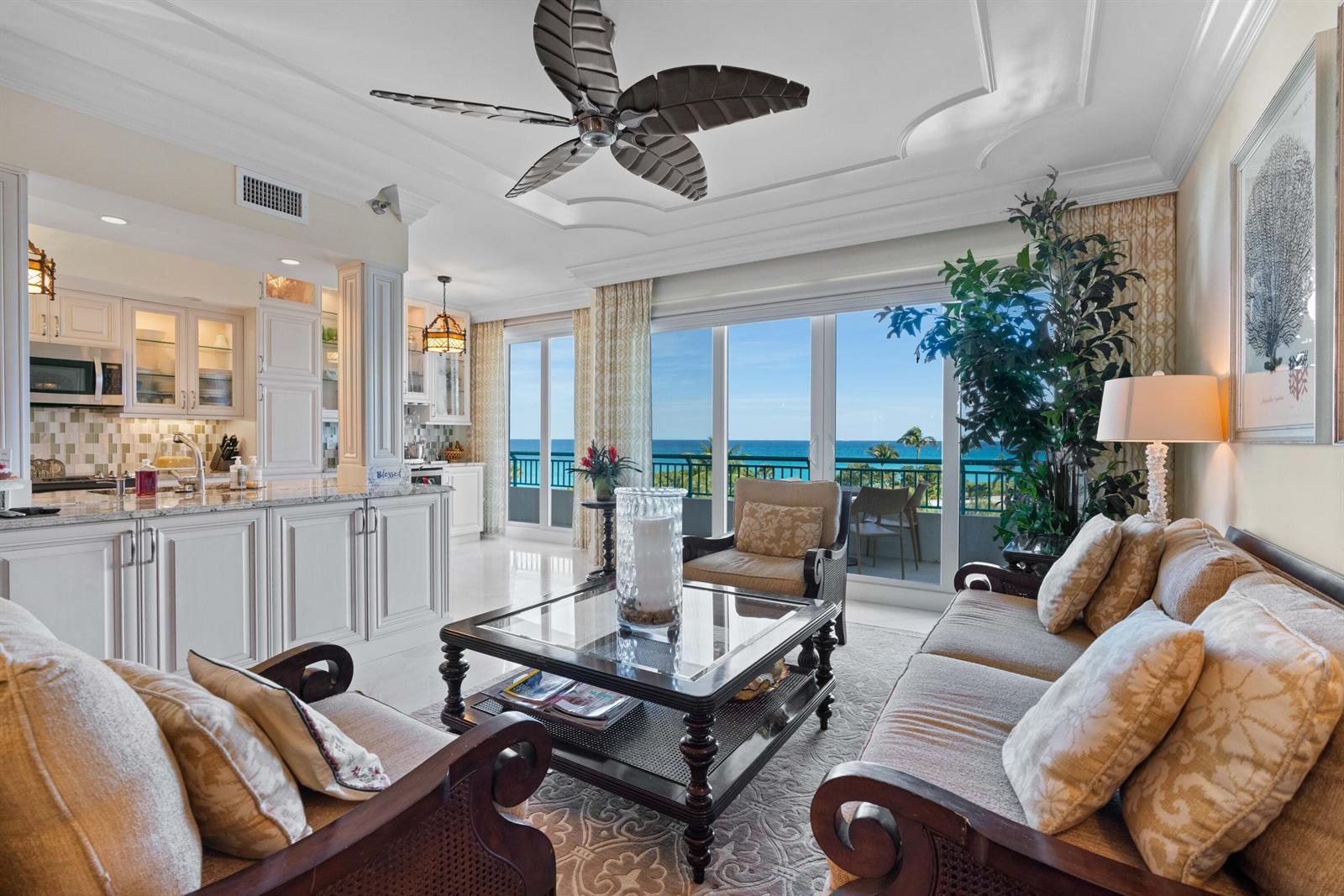 A living room and kitchen area with white cabinetry, a ceiling fan, and ocean views — 2000 S Highway A1a # 406, Jupiter FL 33477, JUPITER, FL